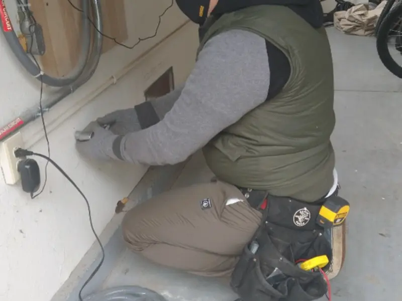 Electrician performing outlet wiring in a Canfield garage
